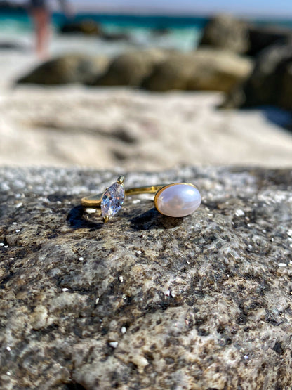 Anillo dorado con perla y circón ovalado