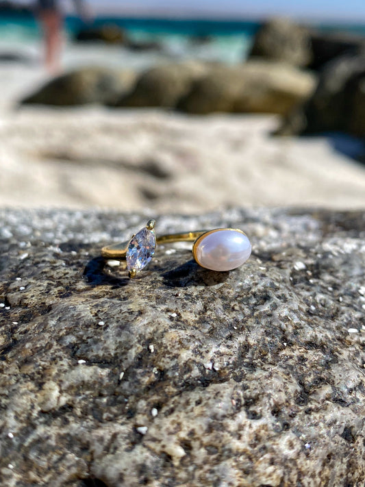 Anillo dorado con perla y circón ovalado