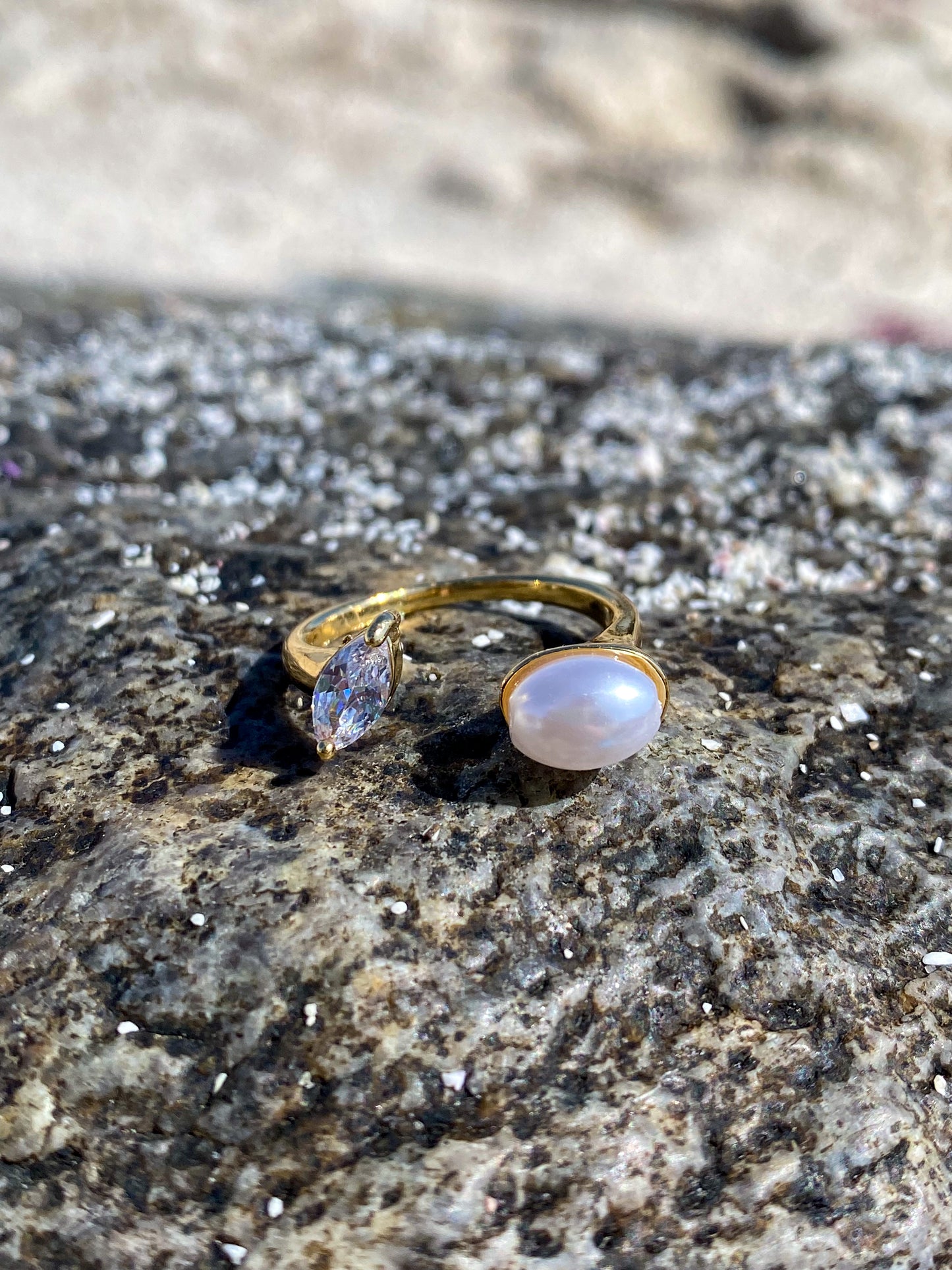 Anillo dorado con perla y circón ovalado